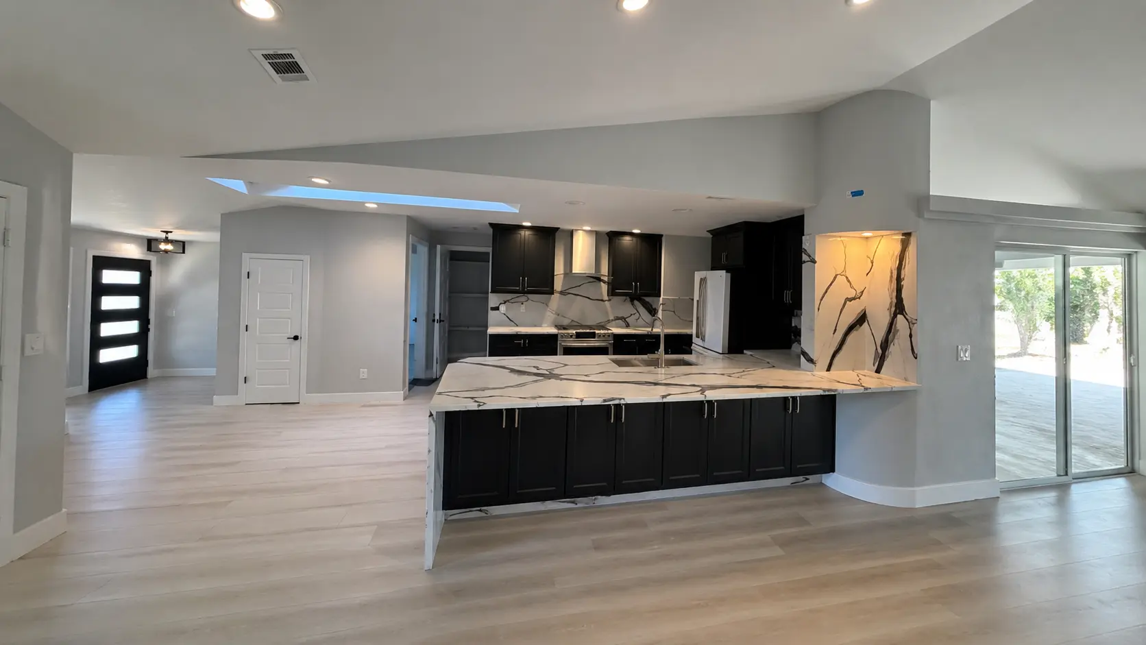 Kitchen remodel — open-plan with marble counter and dark cabinets